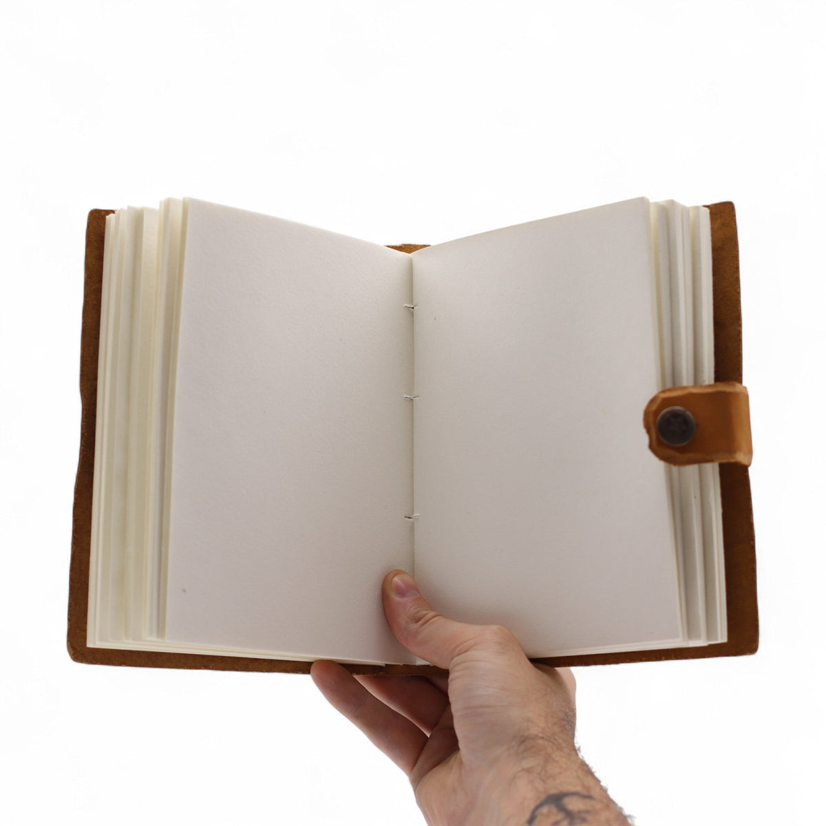 Leather-Bound Floral Notebook - Medium Tan, Strap, 200 Pages held open to blank cream pages with brown cover and strap visible by Quintessential Holistic Health Ltd