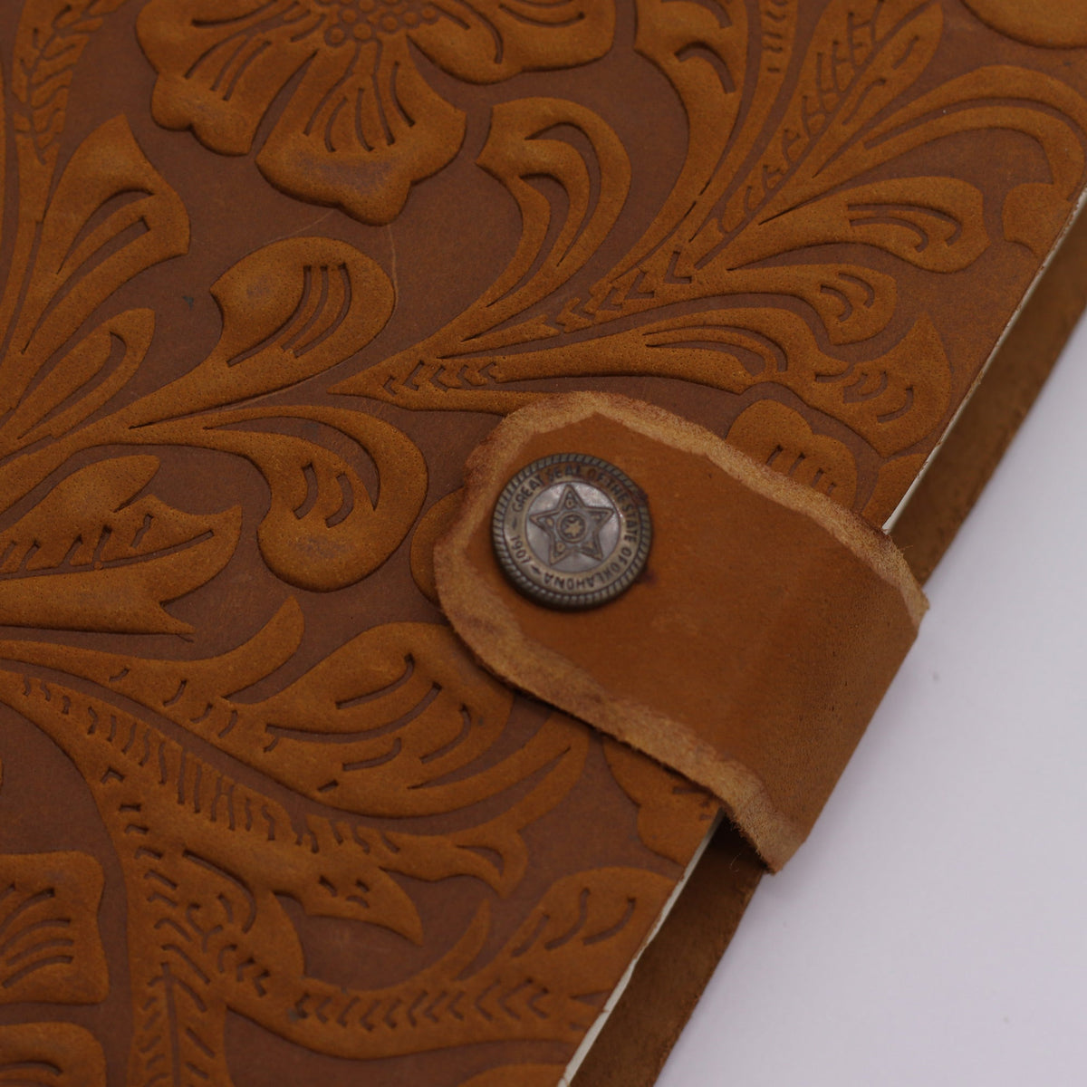 Leather-Bound Floral Notebook - Medium Tan, Strap, 200 Pages close-up showing floral embossing and decorative metal stud by Quintessential Holistic Health Ltd