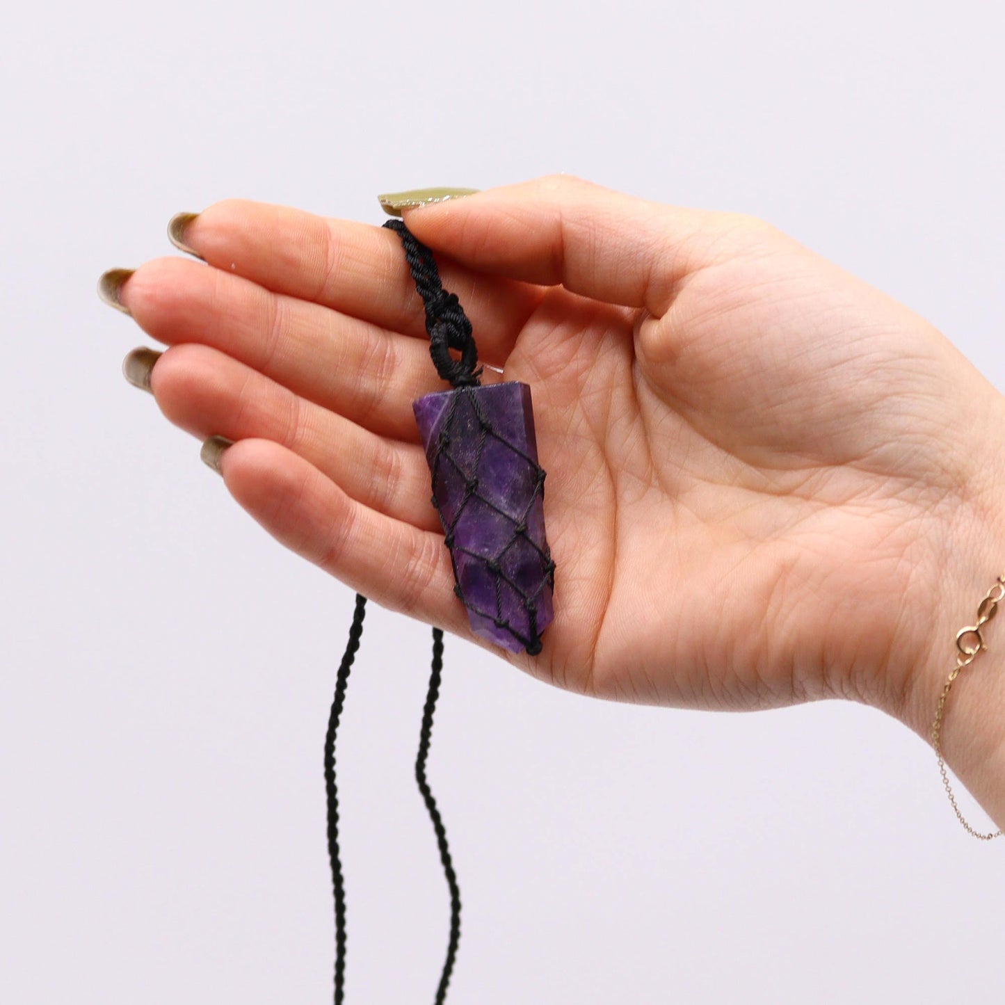 Handmade Laced Gemstone Pendant - Flat Point / Amethyst product packaging on clean background from Quintessential Holistic Health Ltd
