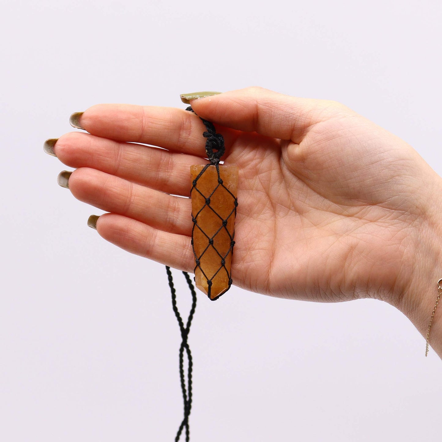 Handmade Laced Gemstone Pendant - Flat Point / Golden Quartz product packaging on clean background from Quintessential Holistic Health Ltd