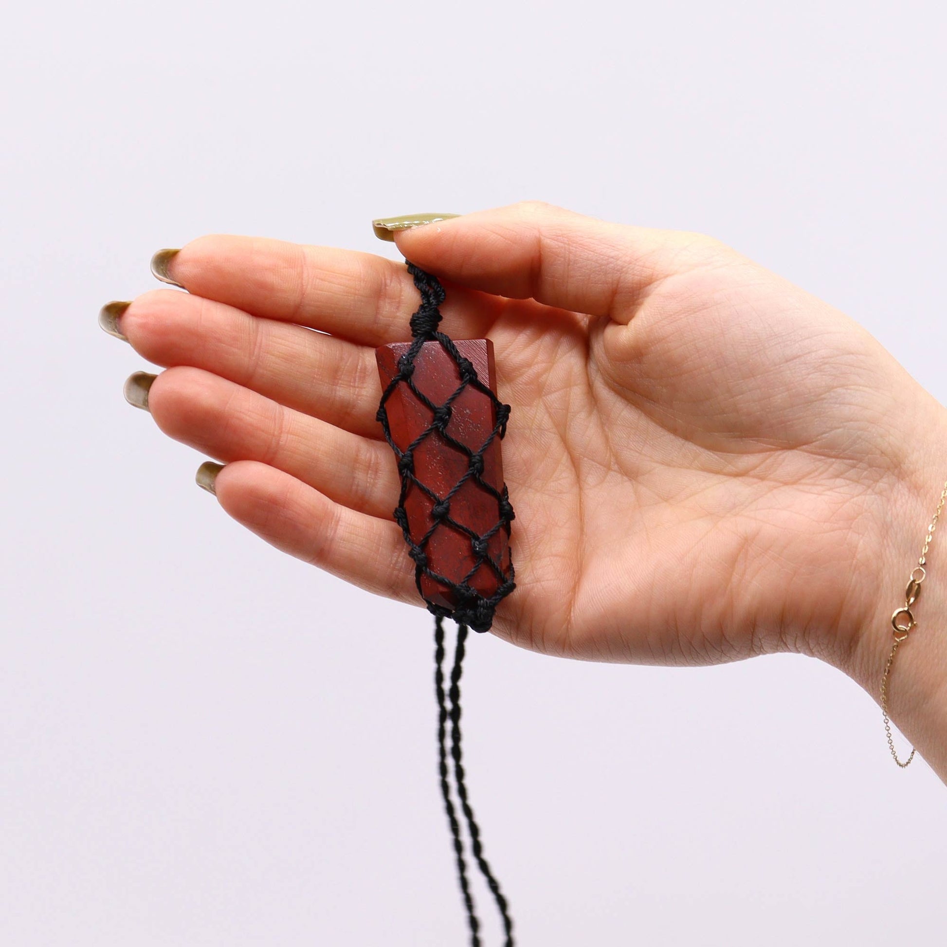 Handmade Laced Gemstone Pendant - Flat Point / Red Jasper product packaging on clean background from Quintessential Holistic Health Ltd