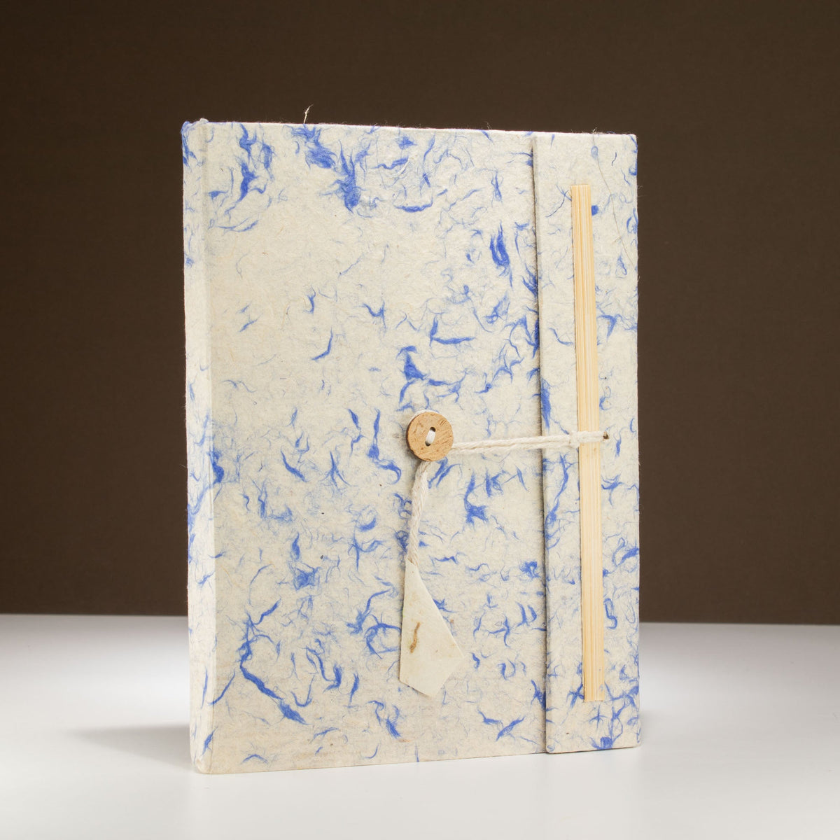 A5 Lokta Paper Notebook & Bookmark - Mixed Blue Cotton, showing the blue-flecked cover with button-and-cord closure upright, by Quintessential Holistic Health Ltd