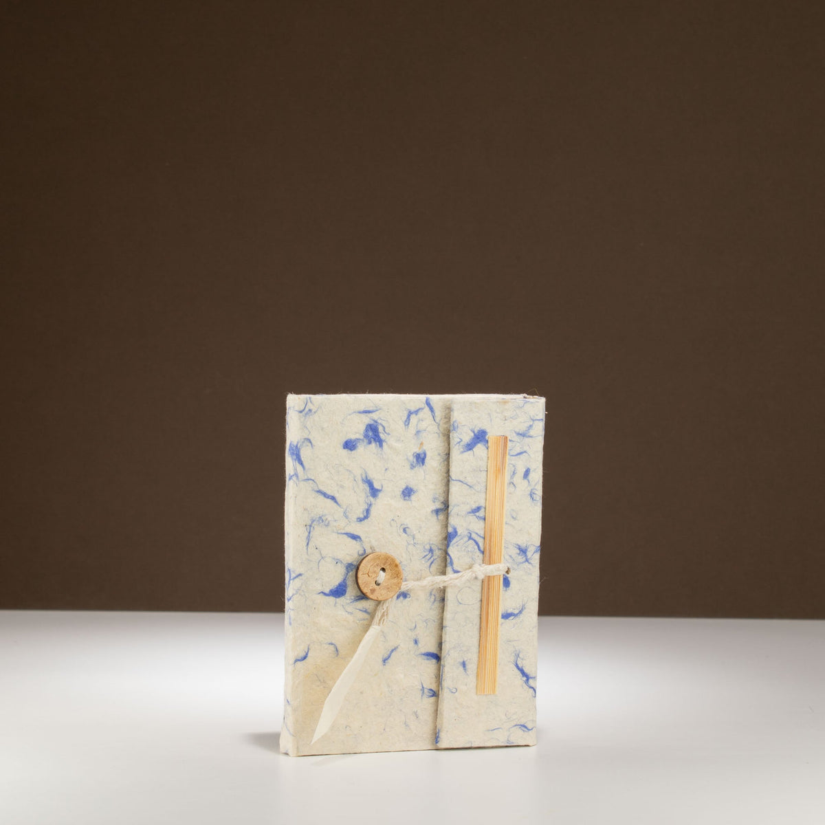 Pocket Eco-Friendly Lokta Paper Notebook - Mixed Blue Cotton, upright blue-flecked cream notebook with wooden toggle fastening by Quintessential Holistic Health Ltd