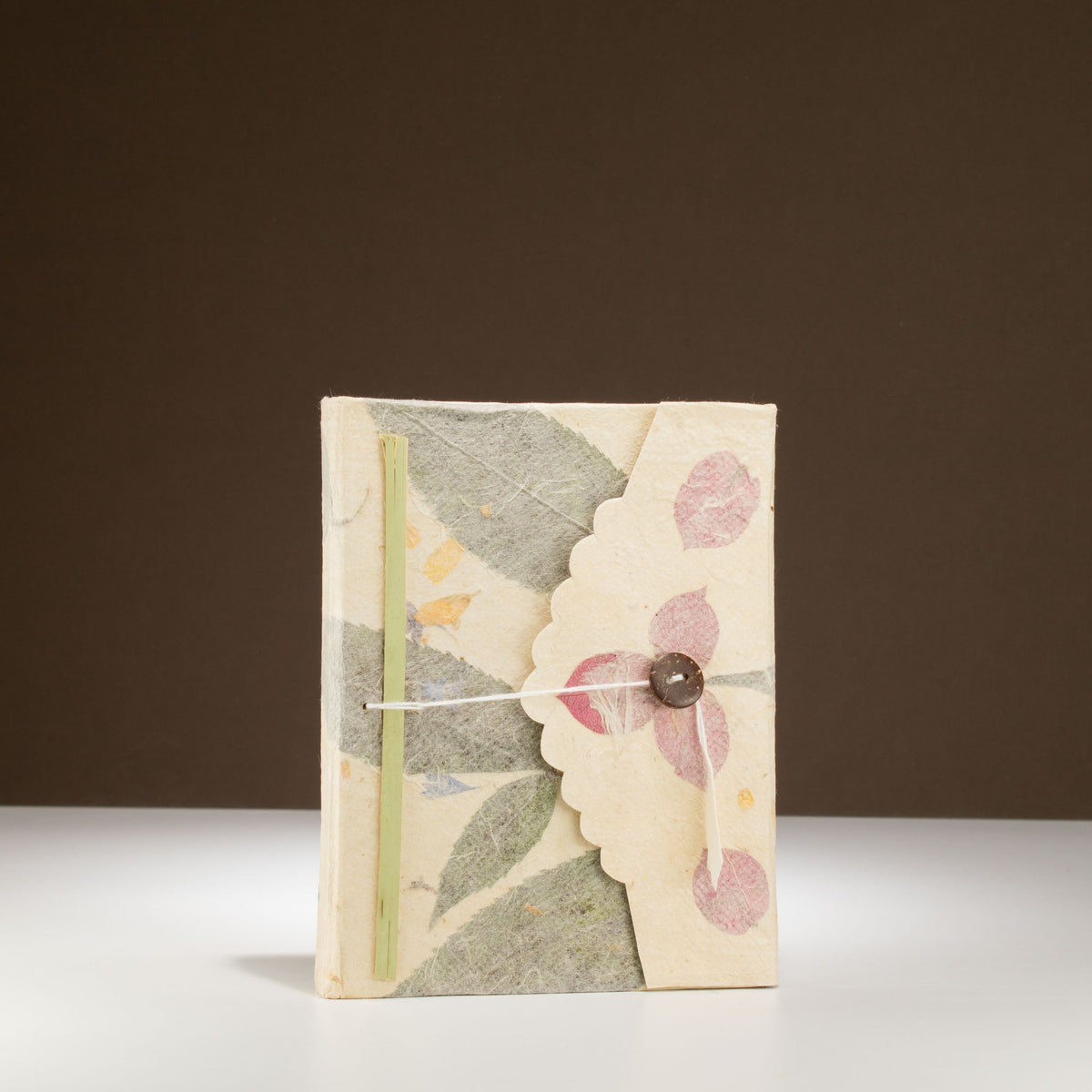 Eco-Friendly Lokta Paper Notebook - A6 - Bougainvillea, standing upright with pink flowers, pale green leaves and a round button by Quintessential Holistic Health Ltd
