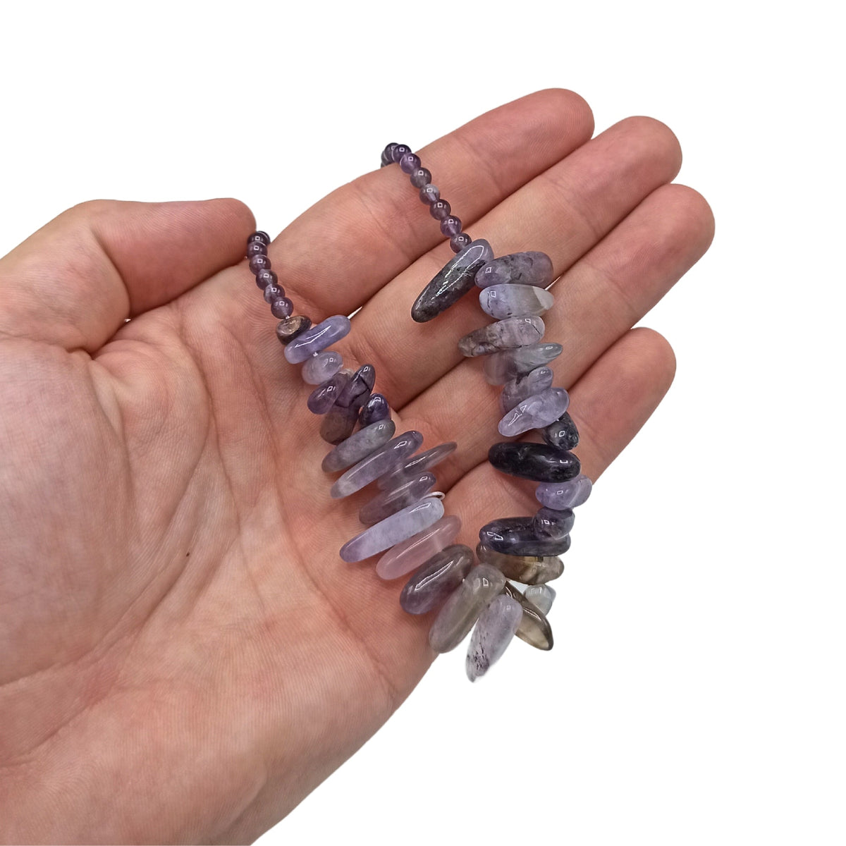 Longstone Gem Necklace - Amethyst held in a hand with translucent purple beads and varied pointed stone drops by Quintessential Holistic Health Ltd