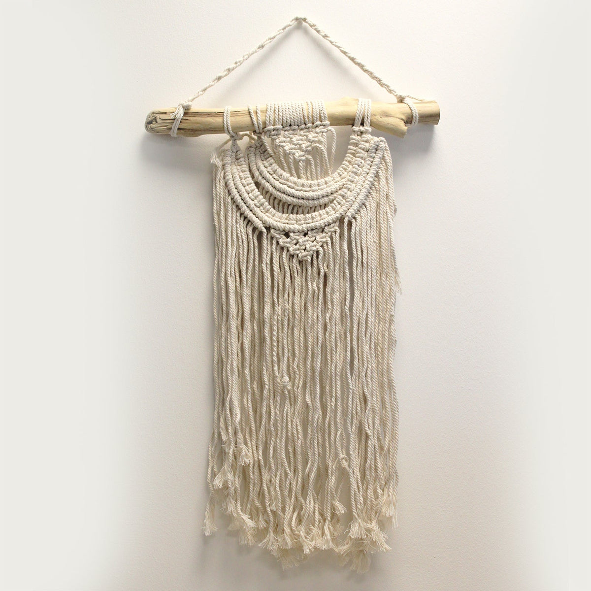 Handcrafted Cotton Macramé Wall Hanging - Two Waves with curved knotted bands and long straight fringe suspended from a branch by Quintessential Holistic Health Ltd