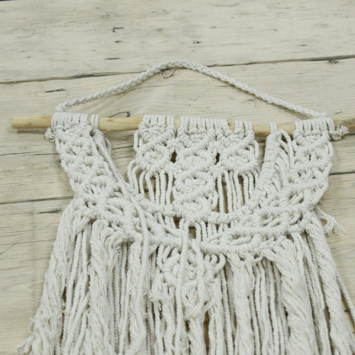 Handcrafted Cotton Macramé Wall Hanging - The Wedding Blessing showing symmetrical knotted panels and central loops beneath a wooden dowel by Quintessential Holistic Health Ltd