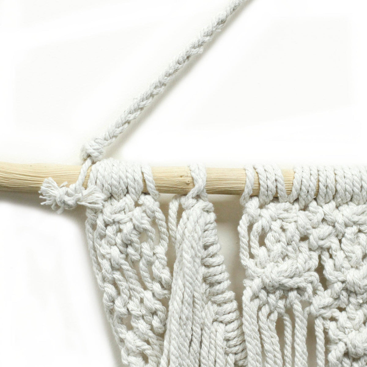 Handcrafted Cotton Macramé Wall Hanging - The Wedding Blessing showing close-up knotted cords looped over a wooden dowel by Quintessential Holistic Health Ltd
