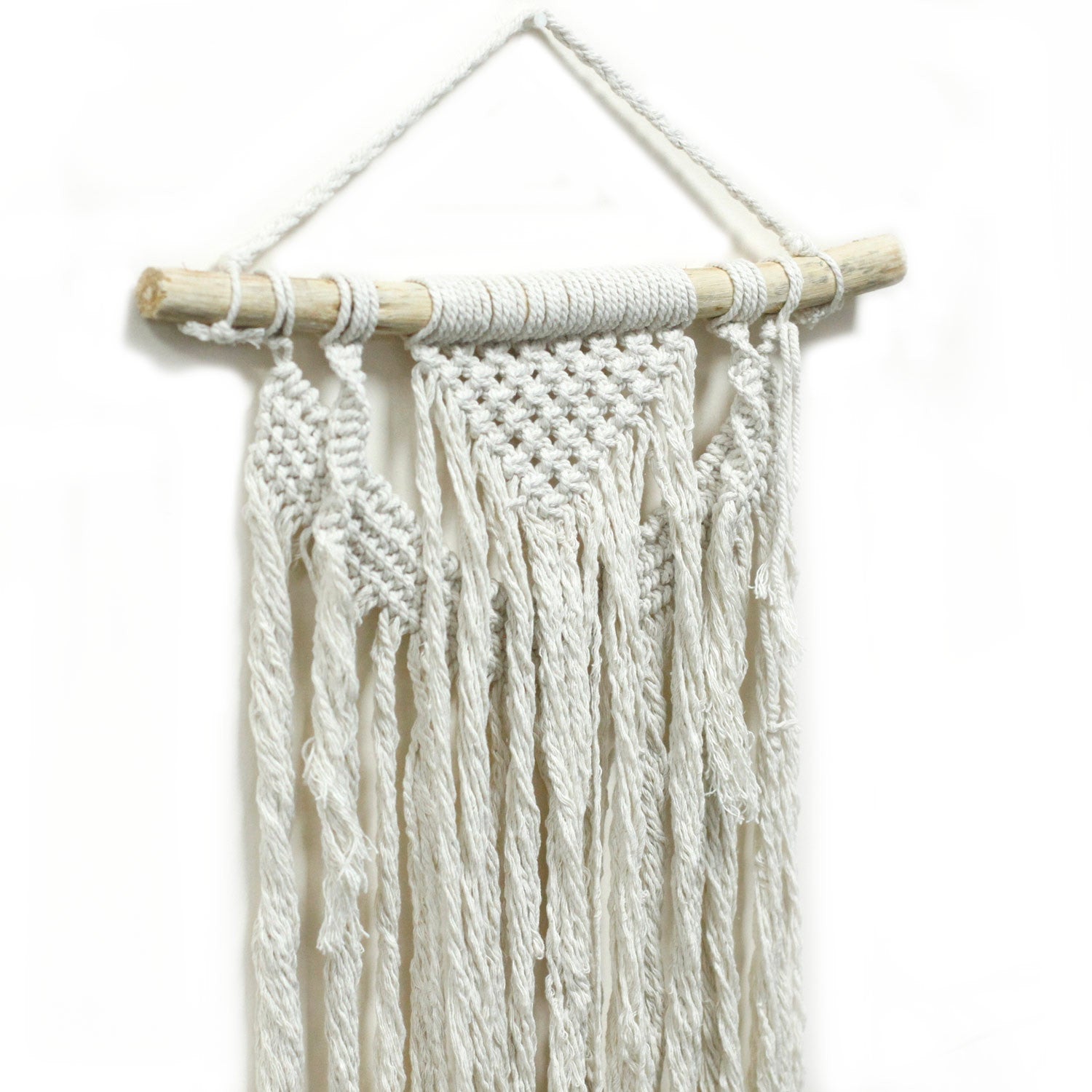 Handcrafted Cotton Macramé Wall Hanging - Force of Nature, close-up of diagonal knotwork, twisted cords and long fringe on a branch by Quintessential Holistic Health Ltd