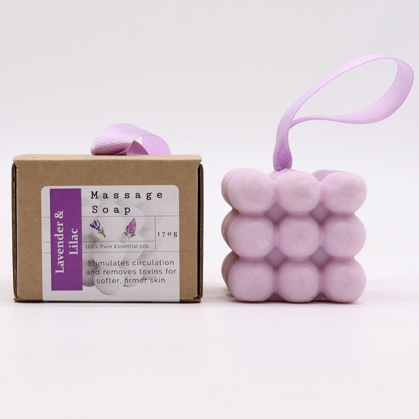Massage Soap Bar - Lavender and Lilac, with a pale purple bubble design and purple loop beside a labelled brown box by Quintessential Holistic Health Ltd