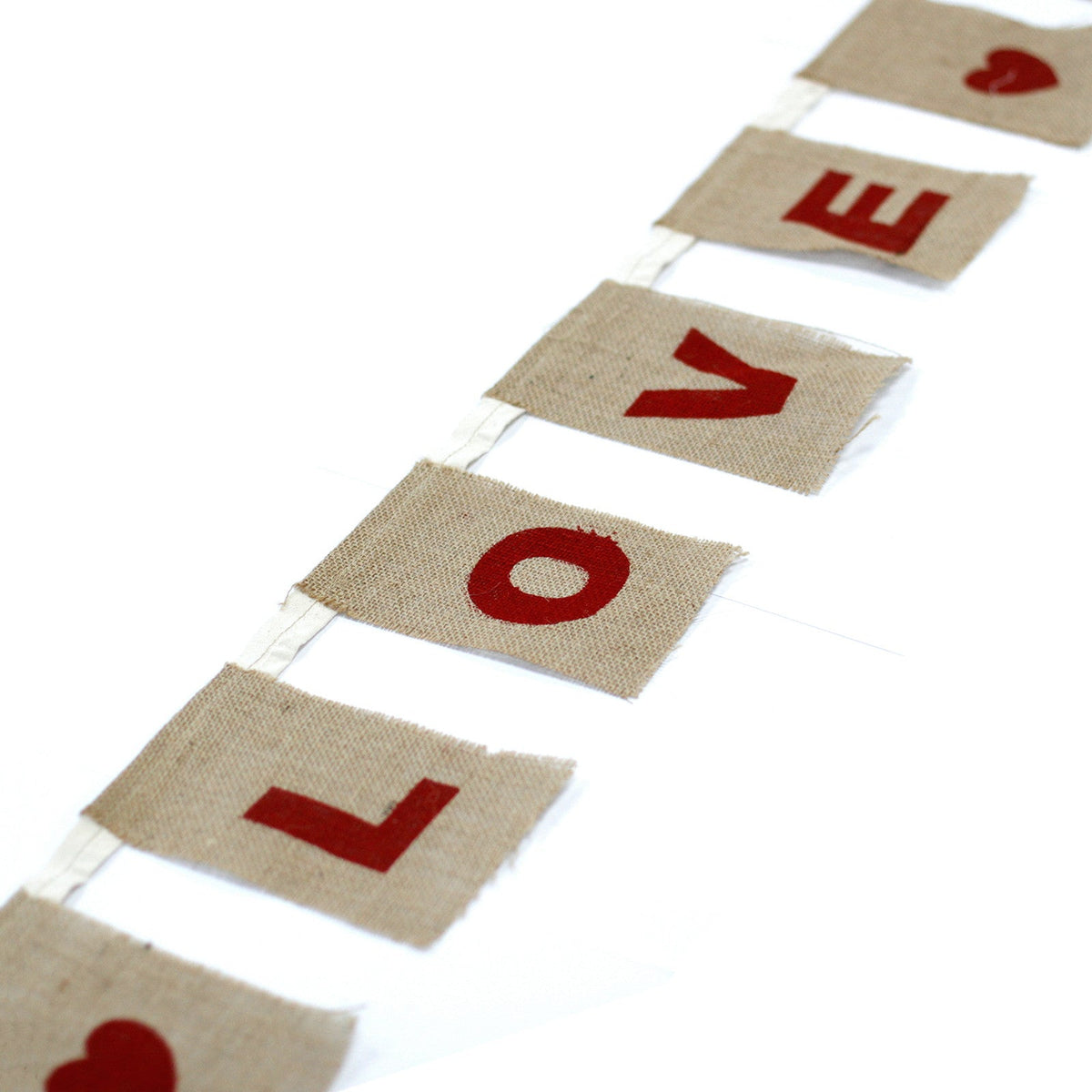 Natural Cotton Bunting - I Love You with Hearts shown in a close diagonal view of red letter and heart panels by Quintessential Holistic Health Ltd