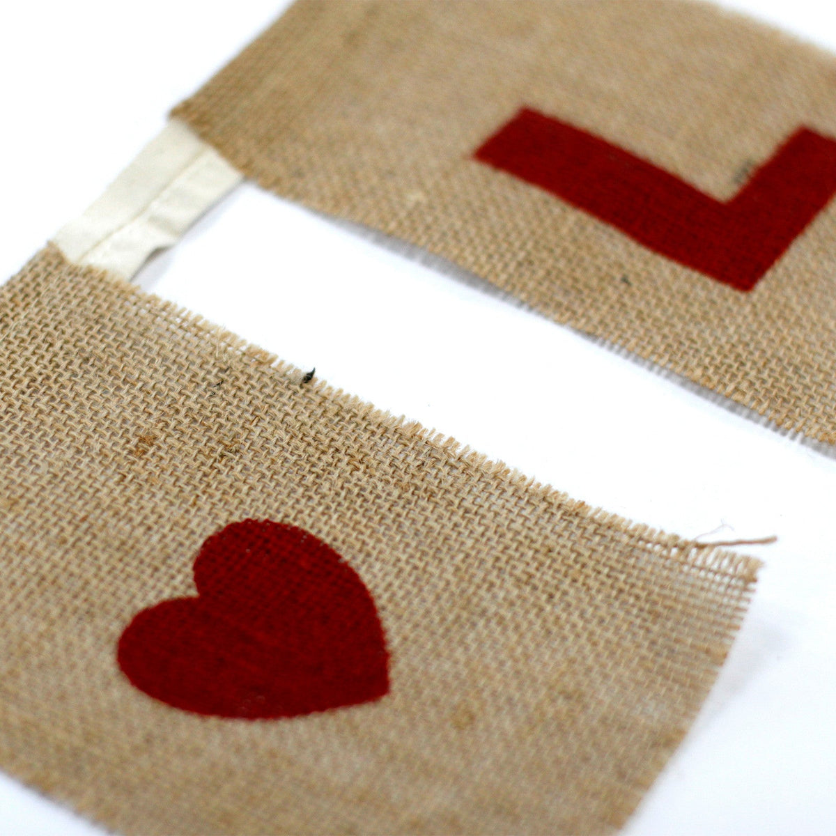 Natural Cotton Bunting - I Love You with Hearts showing a close-up of a beige panel with a red heart beside a letter panel by Quintessential Holistic Health Ltd