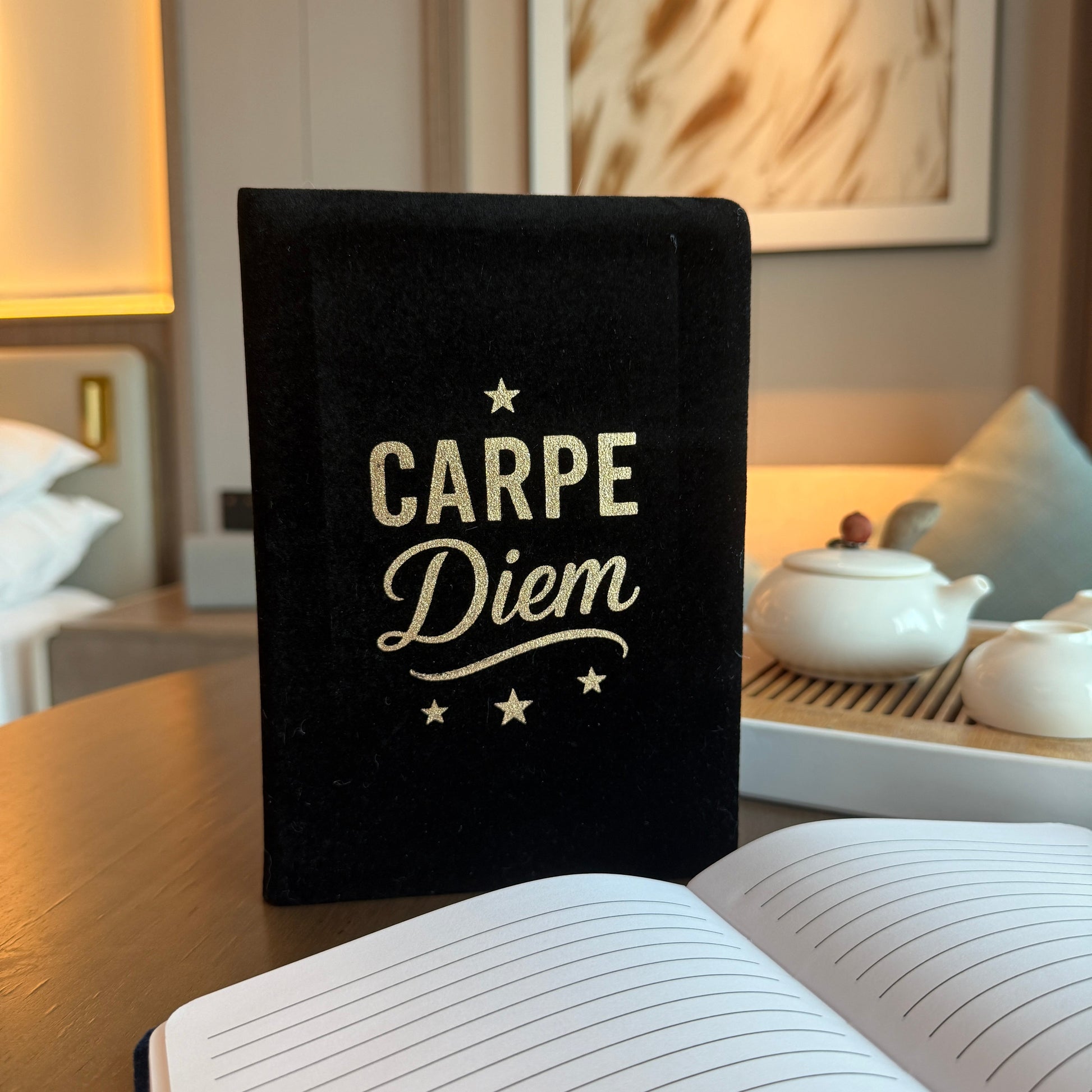 Velvet Journal - A5 - Black - Carpe Diem, standing behind an open lined journal by Quintessential Holistic Health Ltd