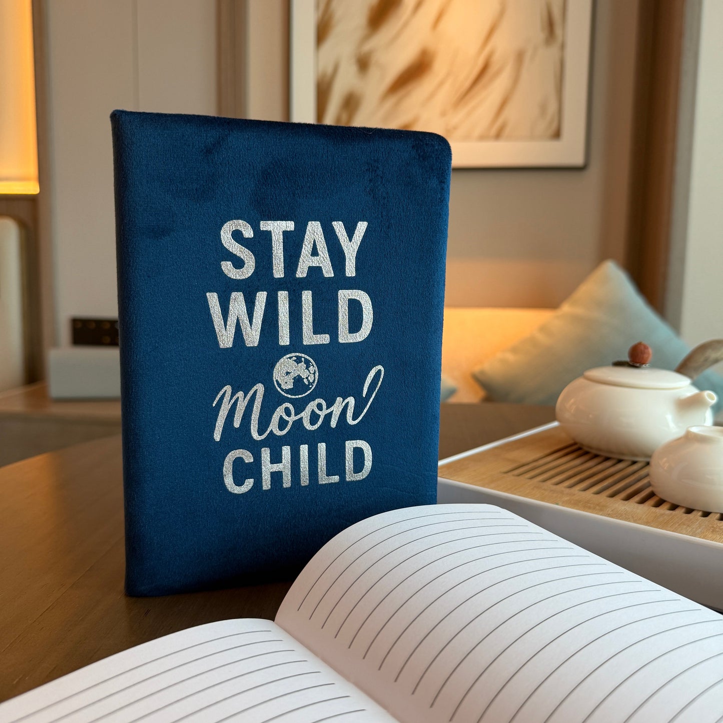 A5 Dark Blue Velvet Journal - Stay Wild Moon Child, upright closed journal beside an open lined journal by Quintessential Holistic Health Ltd