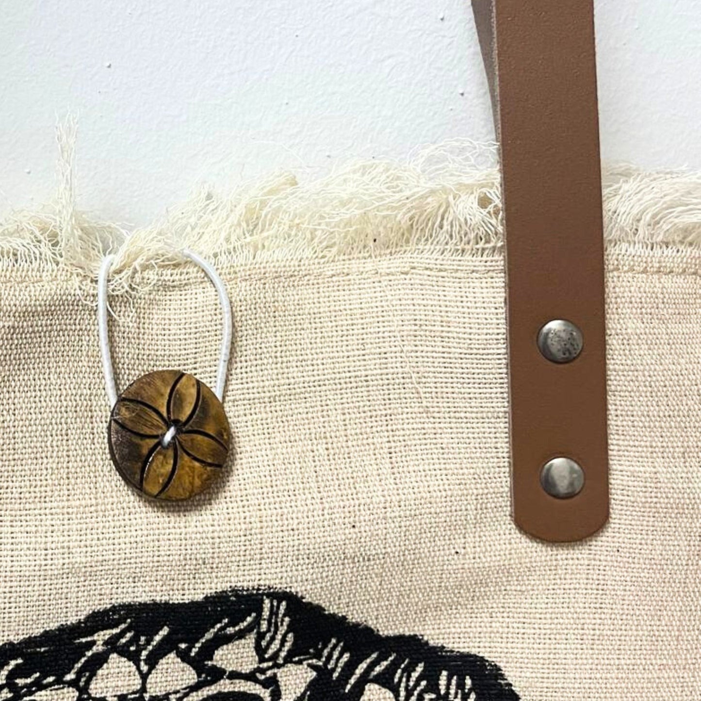 Natural Cotton Tote Bag with Leather Handles - Flower of Life showing a round flower charm, brown strap and metal rivets by Quintessential Holistic Health Ltd