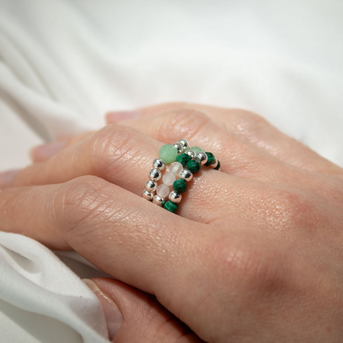 Mystical Nymph Spirit Gemstone 3-Ring Set – Forest Spirit, green, white and silver-toned beaded rings stacked on a hand, by Quintessential Holistic Health Ltd
