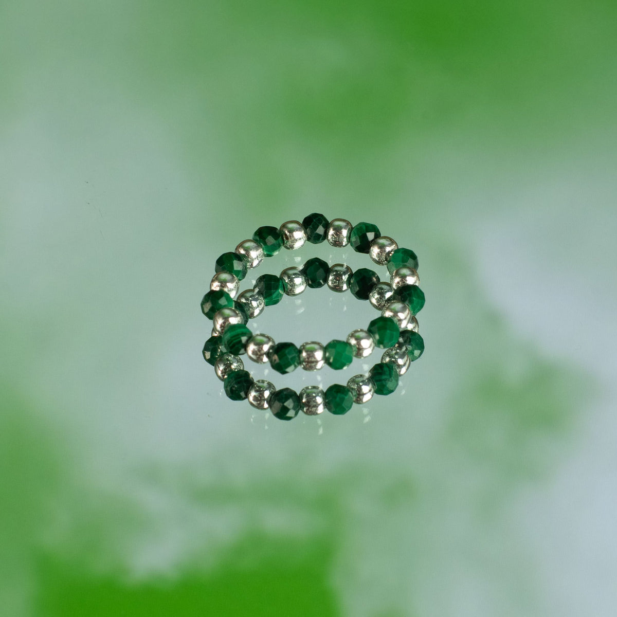 Mystical Nymph Spirit Gemstone 3-Ring Set – Forest Spirit, dark green and silver-toned beaded rings stacked on soft green by Quintessential Holistic Health Ltd