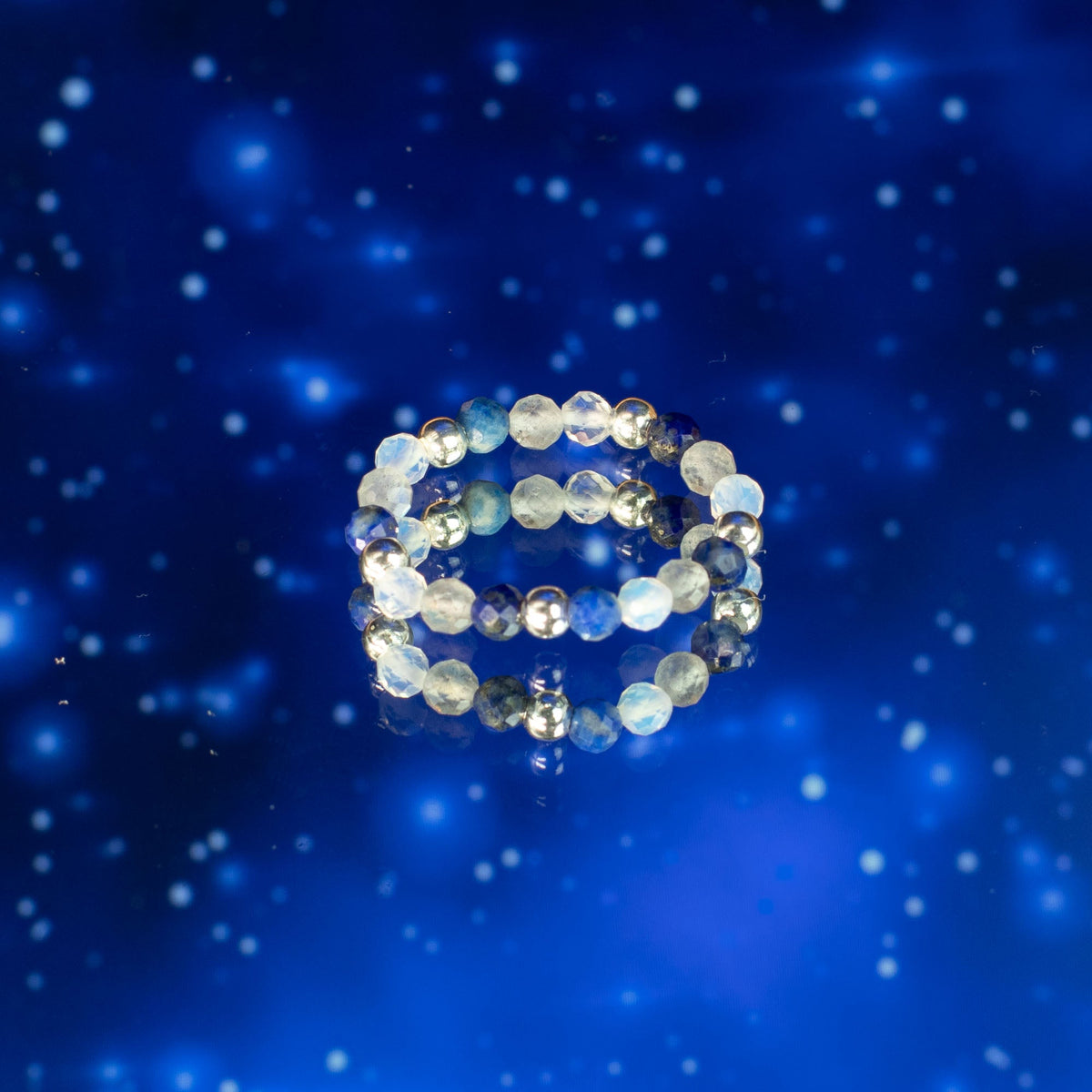 Mystical Nymph Spirit Gemstone 3-Ring Set – Northern Lights, pale blue and silver-toned beaded rings stacked against a starry blue scene, by Quintessential Holistic Health Ltd
