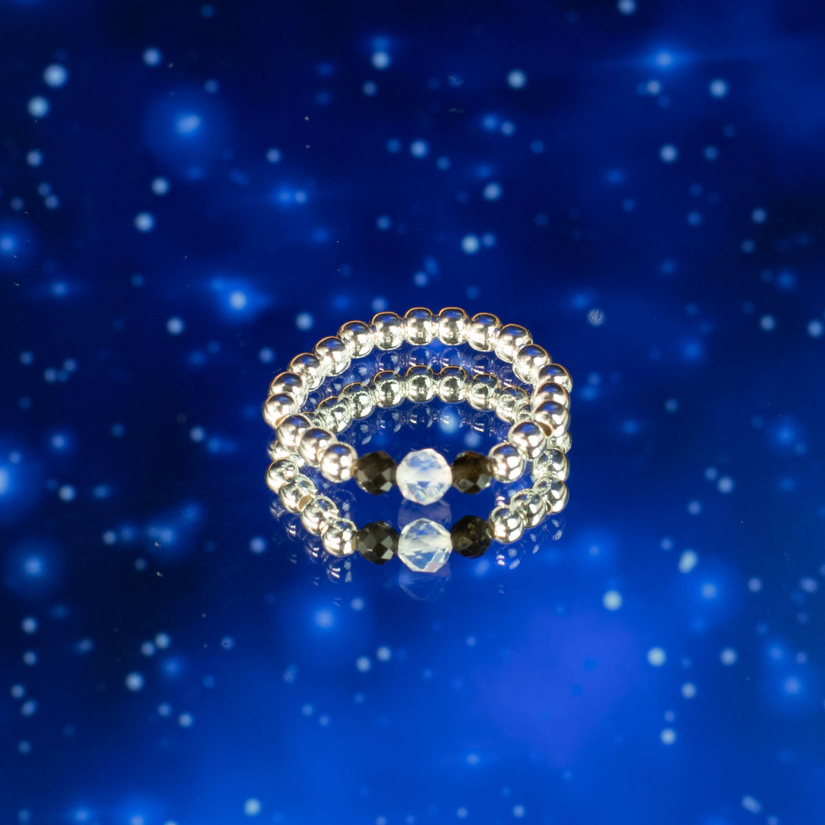 Mystical Nymph Spirit Gemstone 3-Ring Set – Northern Lights, silver-toned and blue beaded rings stacked against a starry blue scene, by Quintessential Holistic Health Ltd
