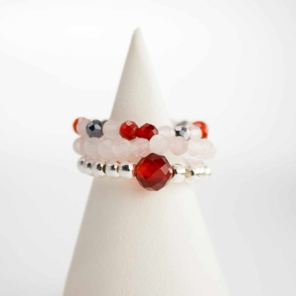 Mystical Nymph Spirit Gemstone 3-Ring Set – Love & Flame, pink, red, white and silver-toned beaded rings stacked on a white cone, by Quintessential Holistic Health Ltd