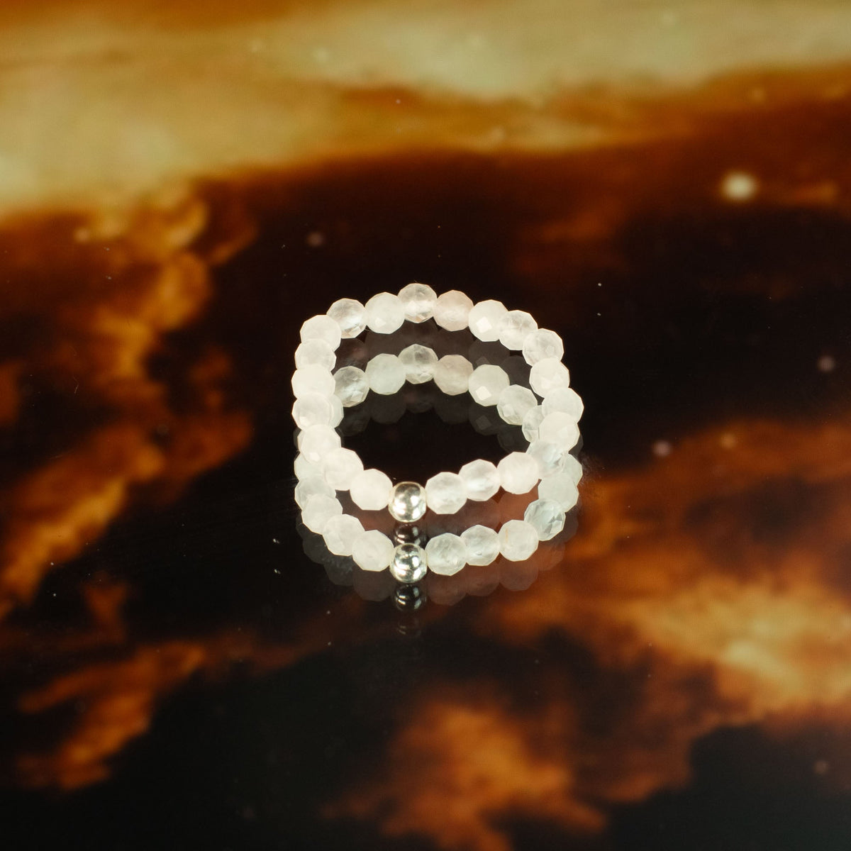 Mystical Nymph Spirit Gemstone 3-Ring Set – Love & Flame, pale pink and white beaded rings stacked on a dark amber surface, by Quintessential Holistic Health Ltd