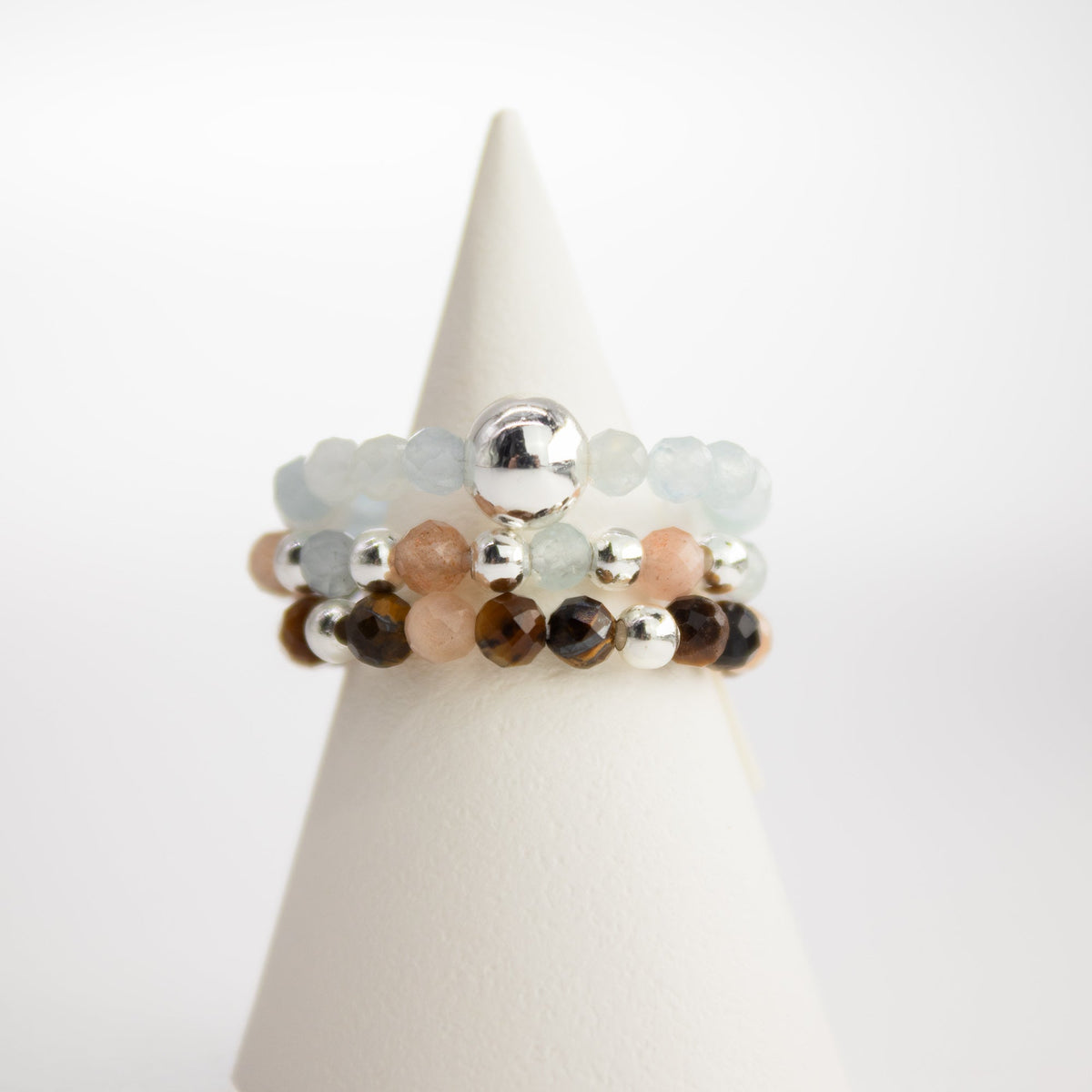 Mystical Nymph Spirit Gemstone 3-Ring Set – Sea Sunset stacked on a tapered white ring stand by Quintessential Holistic Health Ltd
