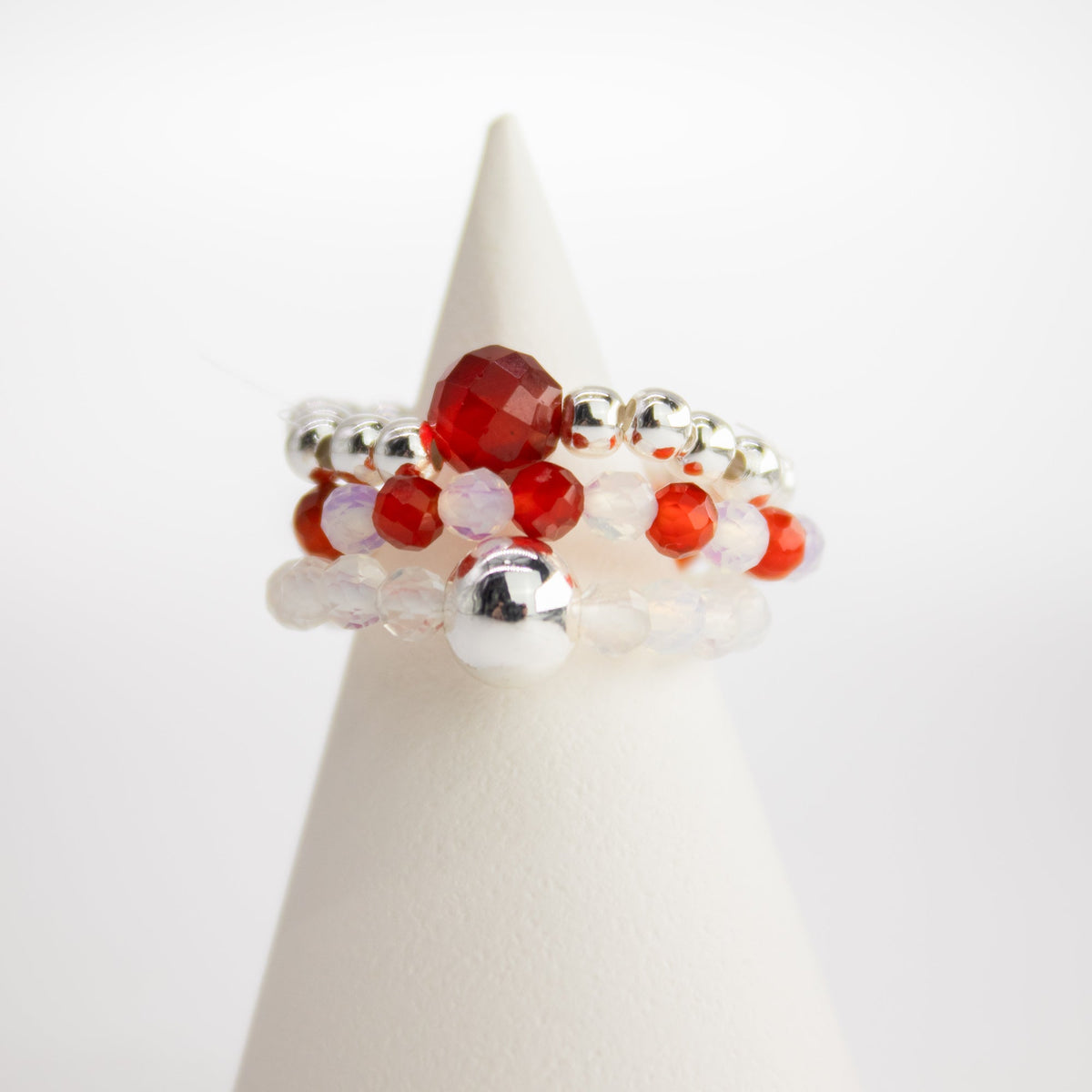 Mystical Nymph Spirit Gemstone 3-Ring Set – Blood Moon, red, pale and silver-toned beaded rings displayed on a white cone by Quintessential Holistic Health Ltd