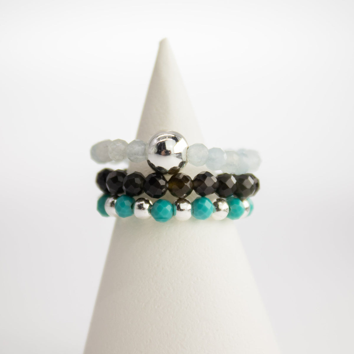Mystical Nymph Spirit Gemstone 3-Ring Set – Endless Ocean, turquoise, dark and pale beaded rings displayed on a white cone by Quintessential Holistic Health Ltd