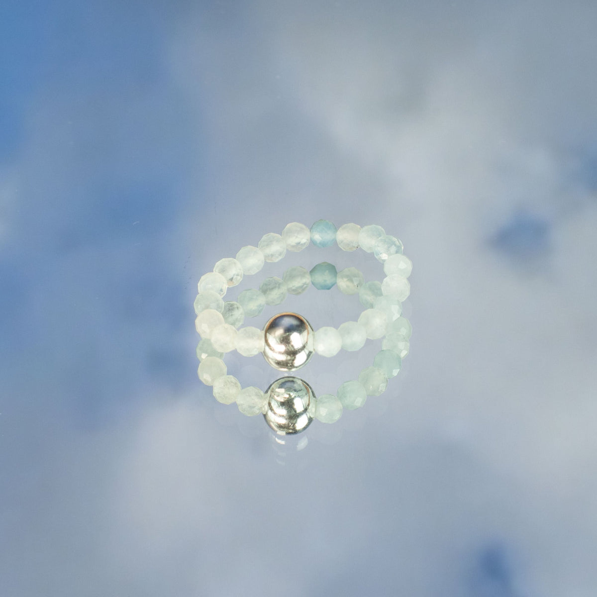 Mystical Nymph Spirit Gemstone 3-Ring Set – Endless Ocean, pale beaded rings stacked with two silver-toned accent beads on cloudy blue by Quintessential Holistic Health Ltd