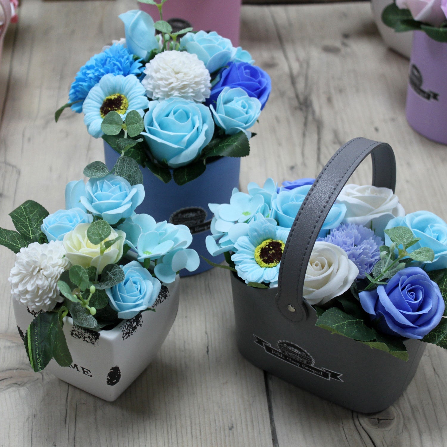 Petite Bouquet Basket - Soothing Blues, three arrangements with blue roses, white blooms and green foliage by Quintessential Holistic Health Ltd