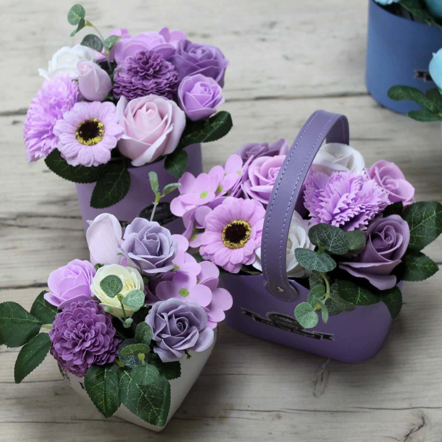 Petite Bouquet Basket - Soft Lavender, three purple floral arrangements with lilac blooms, pale roses and green foliage by Quintessential Holistic Health Ltd