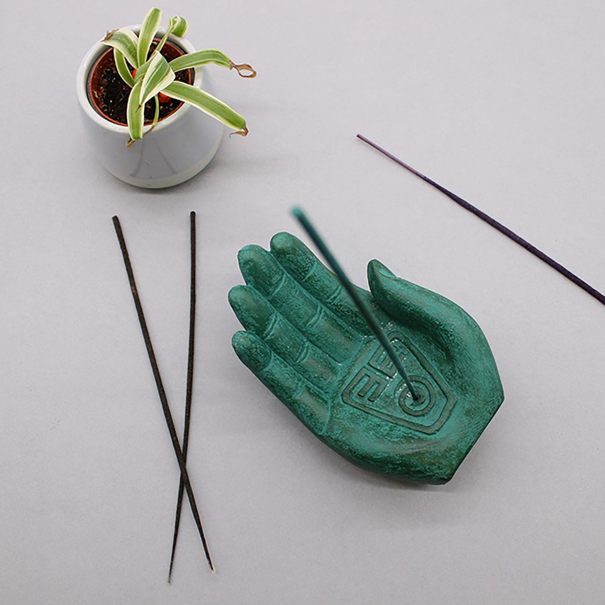 Concrete Incense Burner - Mother Earth - Protection - Green, green open hand beside four dark sticks and a small potted plant, by Quintessential Holistic Health Ltd