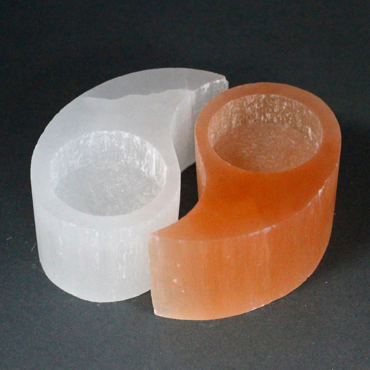 Selenite Yin Yang Candle Holder separated into interlocking orange and white halves with circular recesses by Quintessential Holistic Health Ltd
