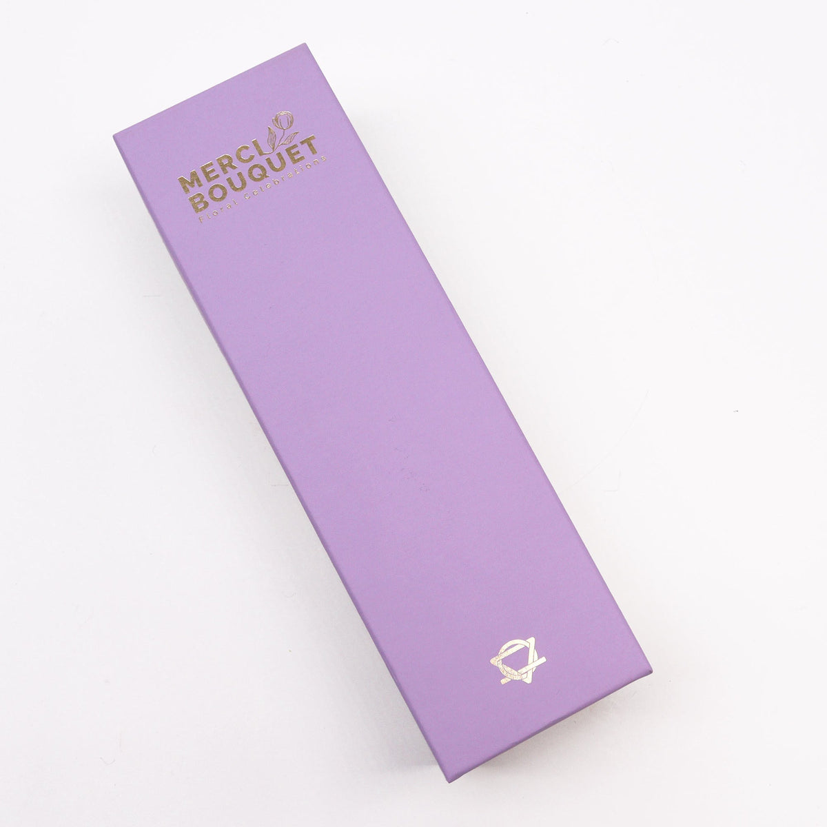 Luxury Soap Flowers - Long - Purples, shown as a closed lavender rectangular box with gold lettering and a gold emblem, by Quintessential Holistic Health Ltd
