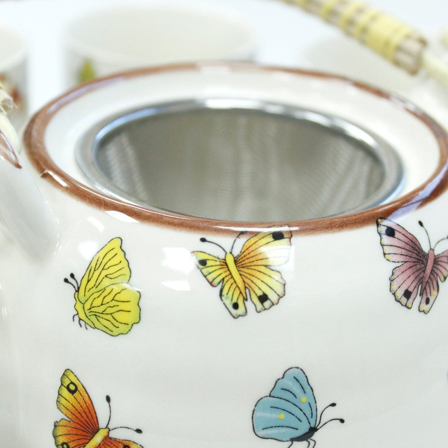 650ml Butterflies Design White Glazed Ceramic Teapot with a Strainer and a 6 Matching Cup Set product packaging on clean background from Quintessential Holistic Health Ltd