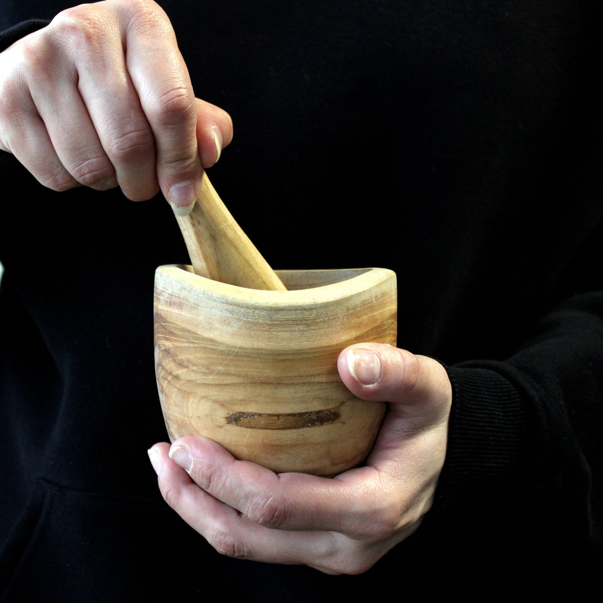 Ergo Teak Pestle & Mortar - Small, wooden mortar held in one hand while the pestle is gripped in the other by Quintessential Holistic Health Ltd