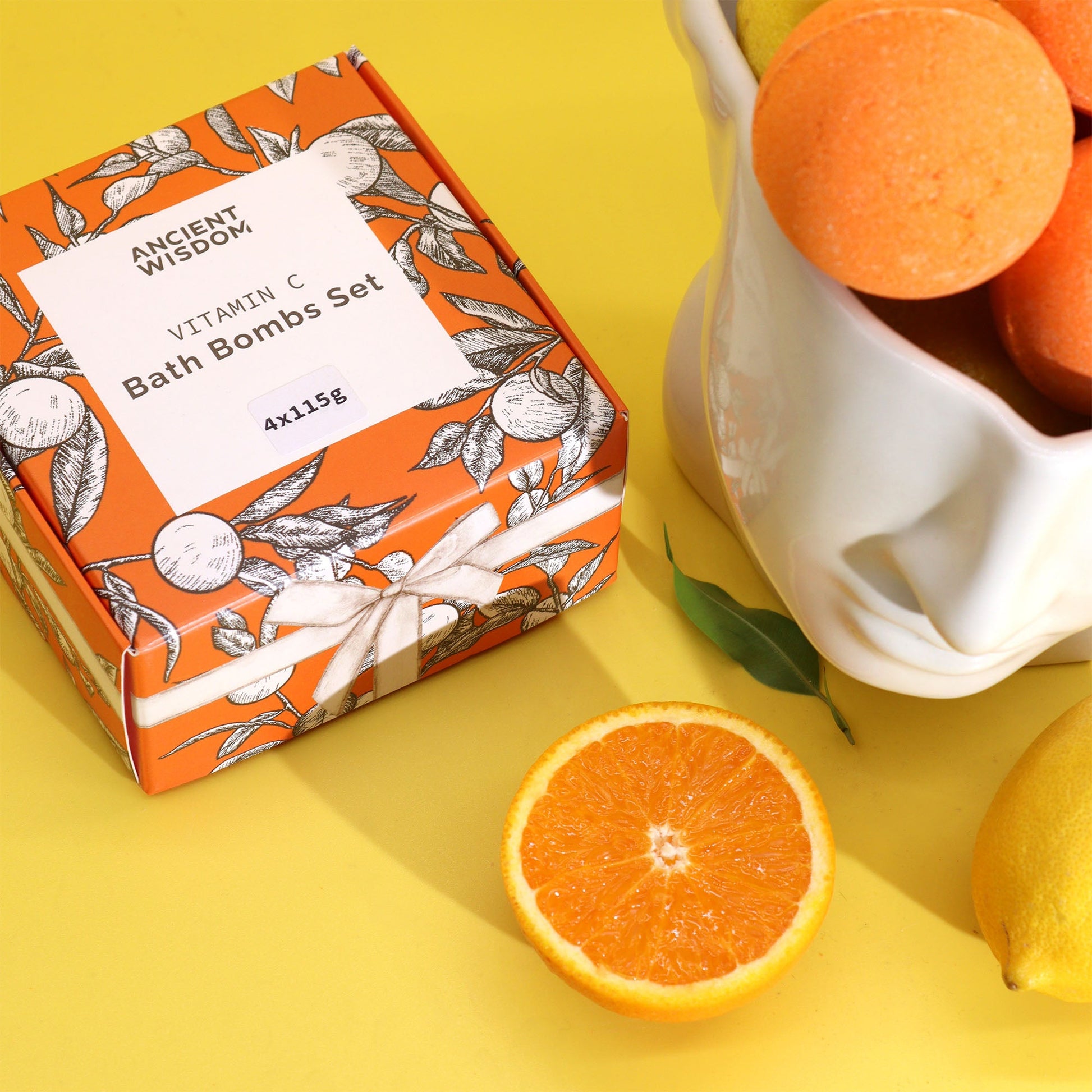 Set of 4 Vitamin C Skincare Bath Bombs - Aromatherapy Quartet, orange patterned box beside orange spheres and sliced citrus fruit by Quintessential Holistic Health Ltd