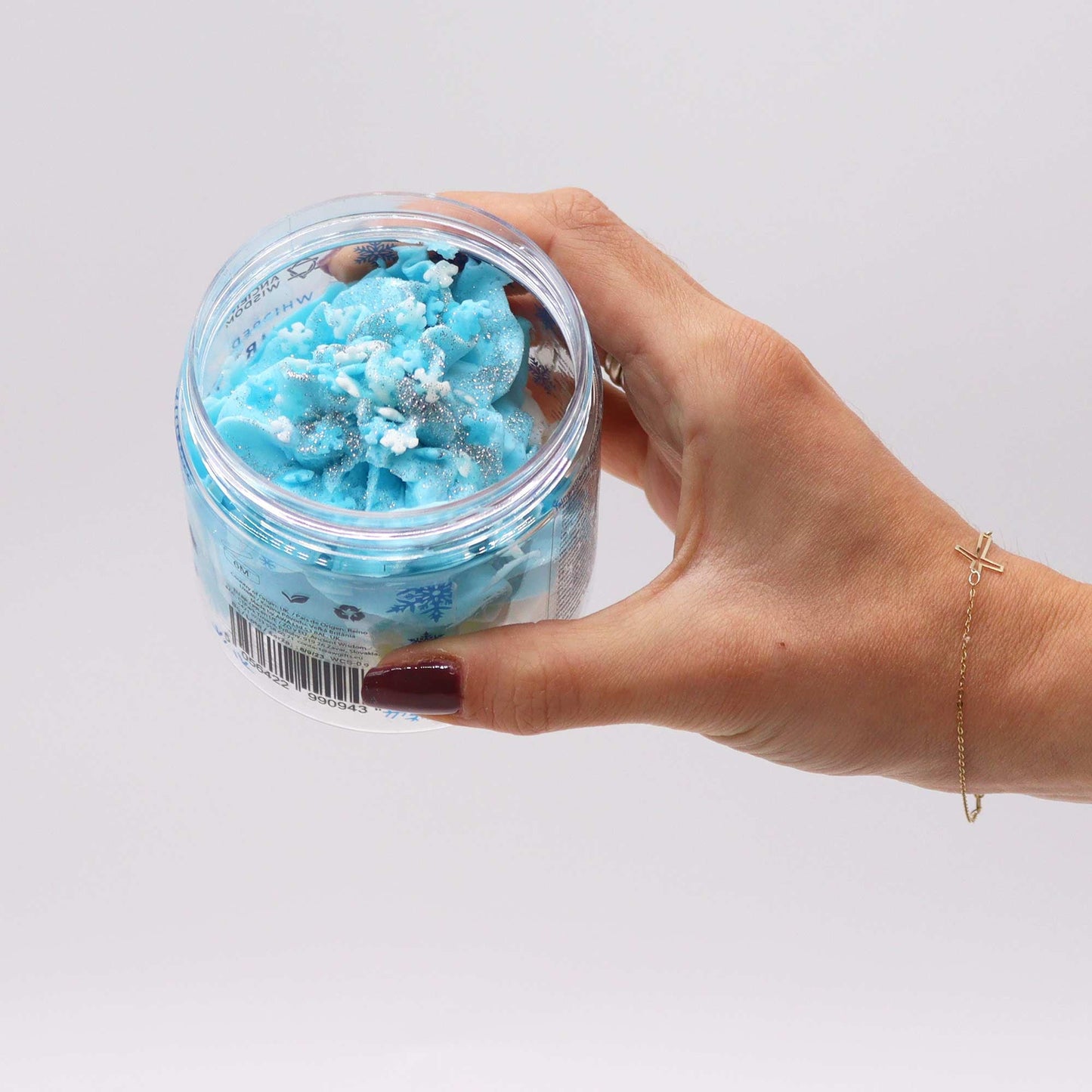 Vegan-Friendly Whipped Soap - White Christmas - 120g, open clear jar of blue-and-white swirls held in one hand by Quintessential Holistic Health Ltd