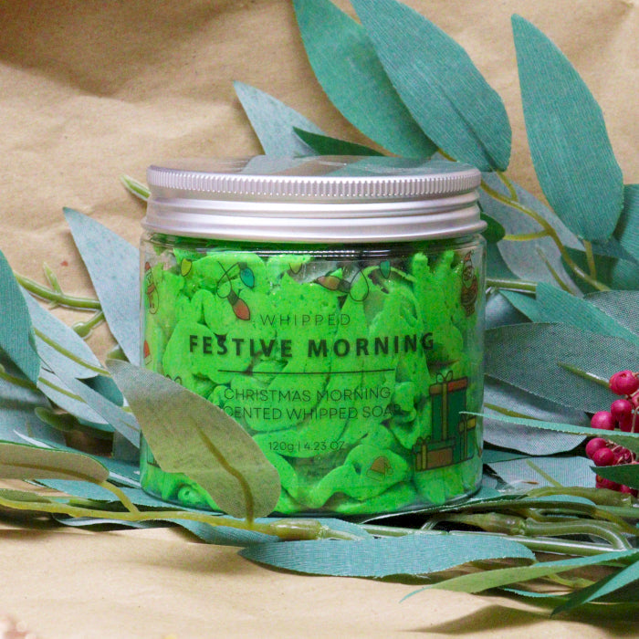 Handcrafted Vegan Friendly Whipped Soap - Festive Morning, closed jar with green contents displayed among leafy stems by Quintessential Holistic Health Ltd