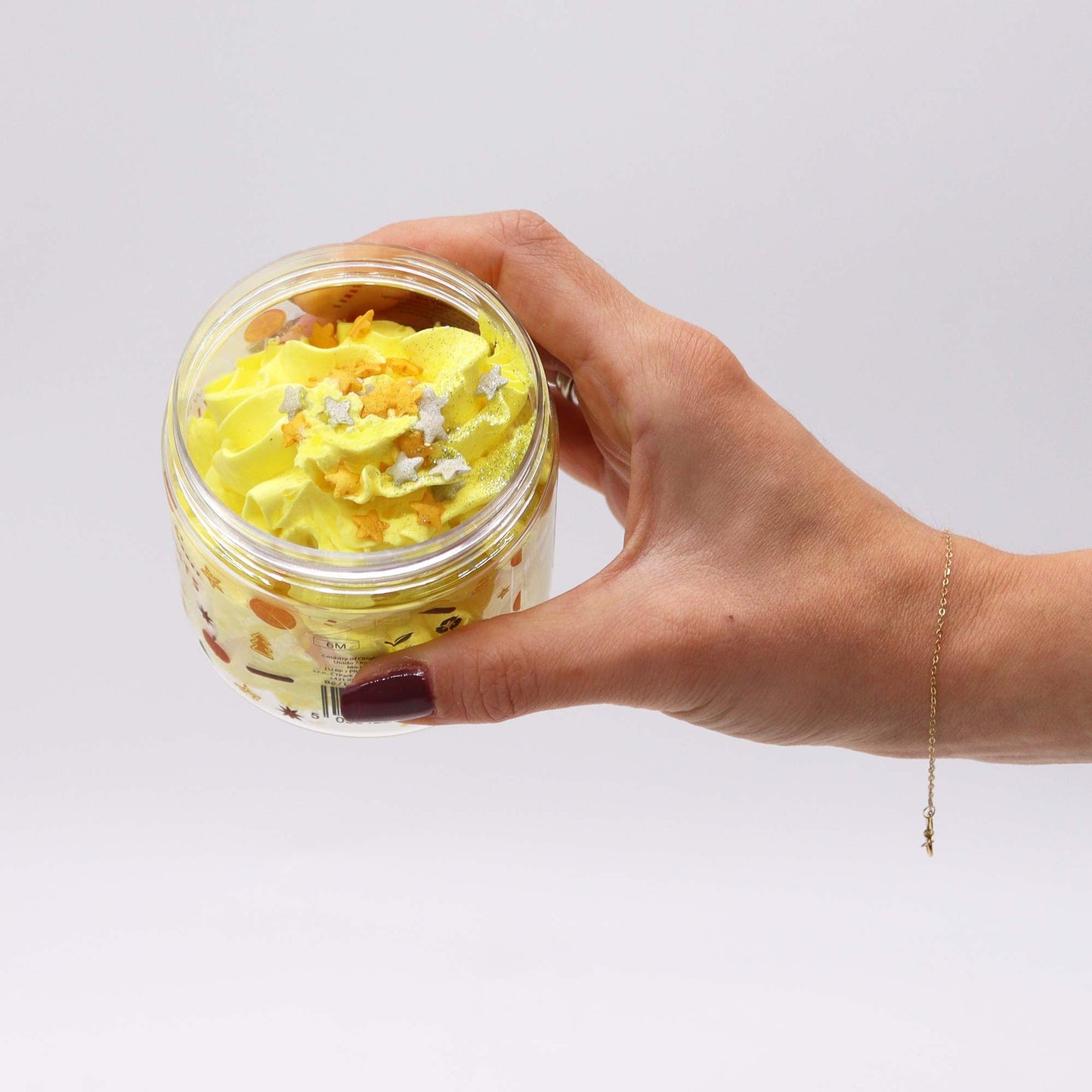 Handcrafted Vegan Friendly Whipped Soap - Cosy Winter Nights in an open jar held in one hand, showing yellow swirls by Quintessential Holistic Health Ltd