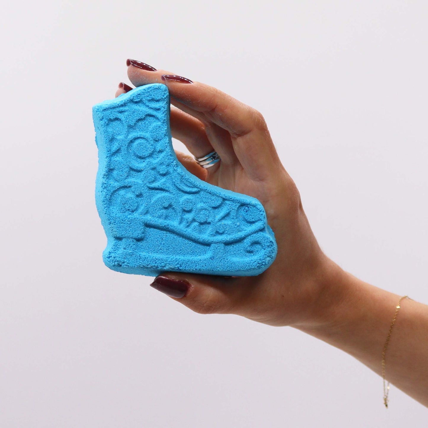 Christmas Bath Bomb Gift Pack - Break the Ice, blue ice-skate-shaped piece held in a hand, by Quintessential Holistic Health Ltd