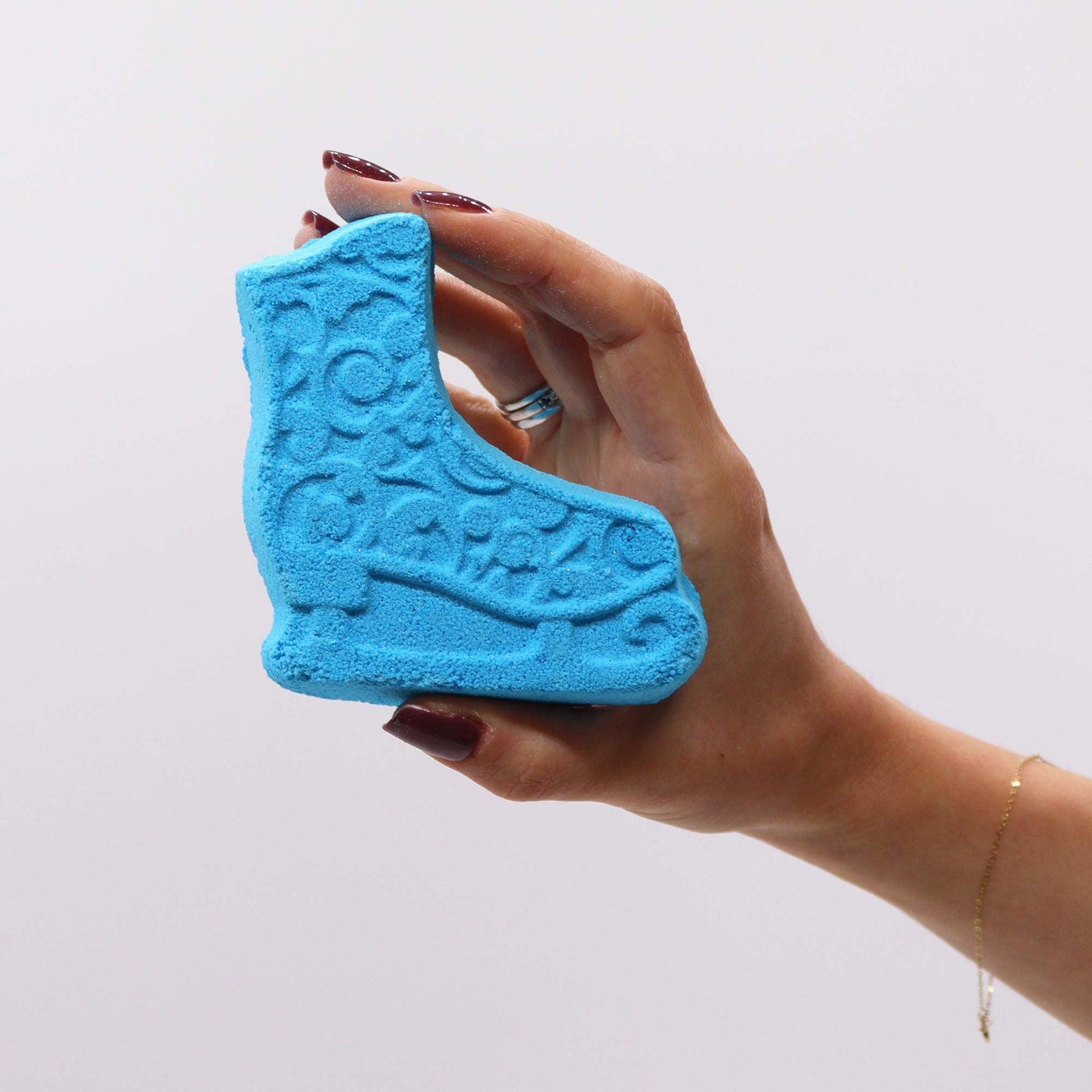 Christmas Bath Bomb Gift Pack - Break the Ice, blue ice-skate-shaped piece held in a hand, by Quintessential Holistic Health Ltd