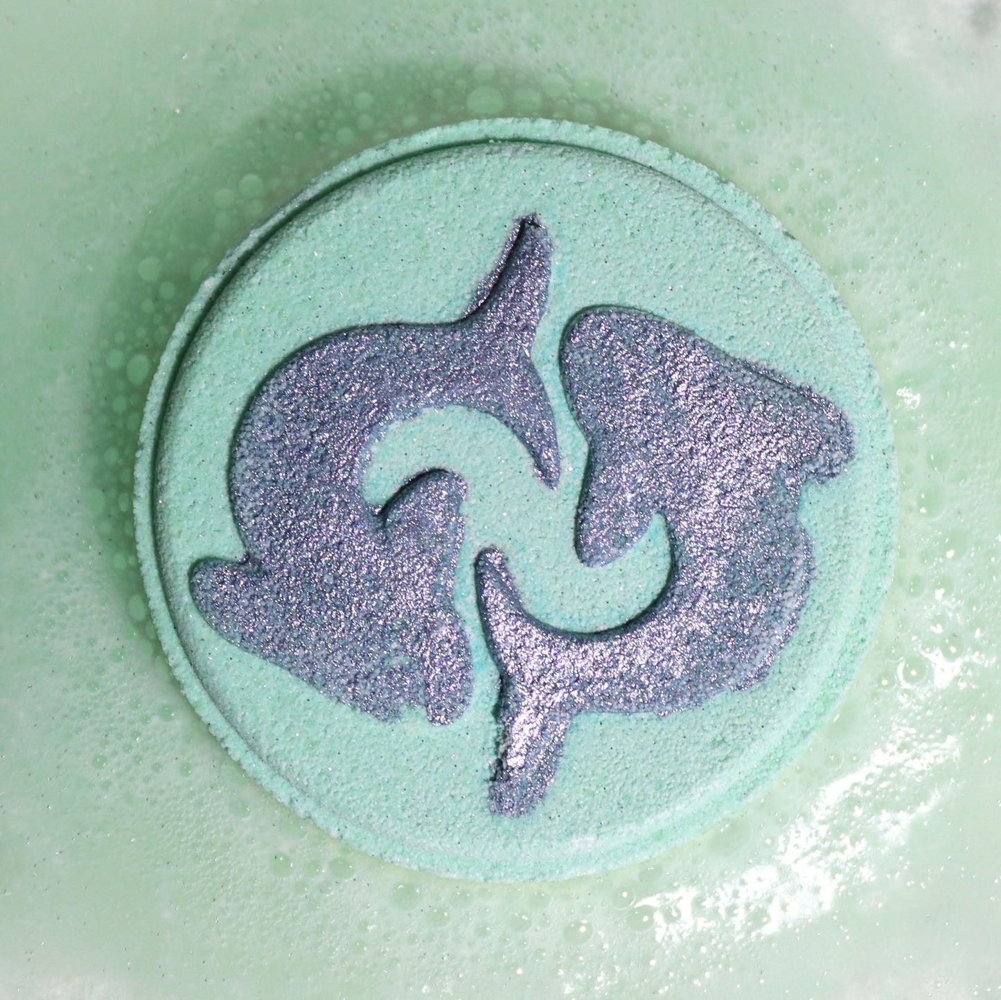 Fragranced Zodiac Horoscope Bath Bomb Fizzers - Pisces - 2 Pack, close-up of a pale green fizzer embossed with the Pisces symbol by Quintessential Holistic Health Ltd