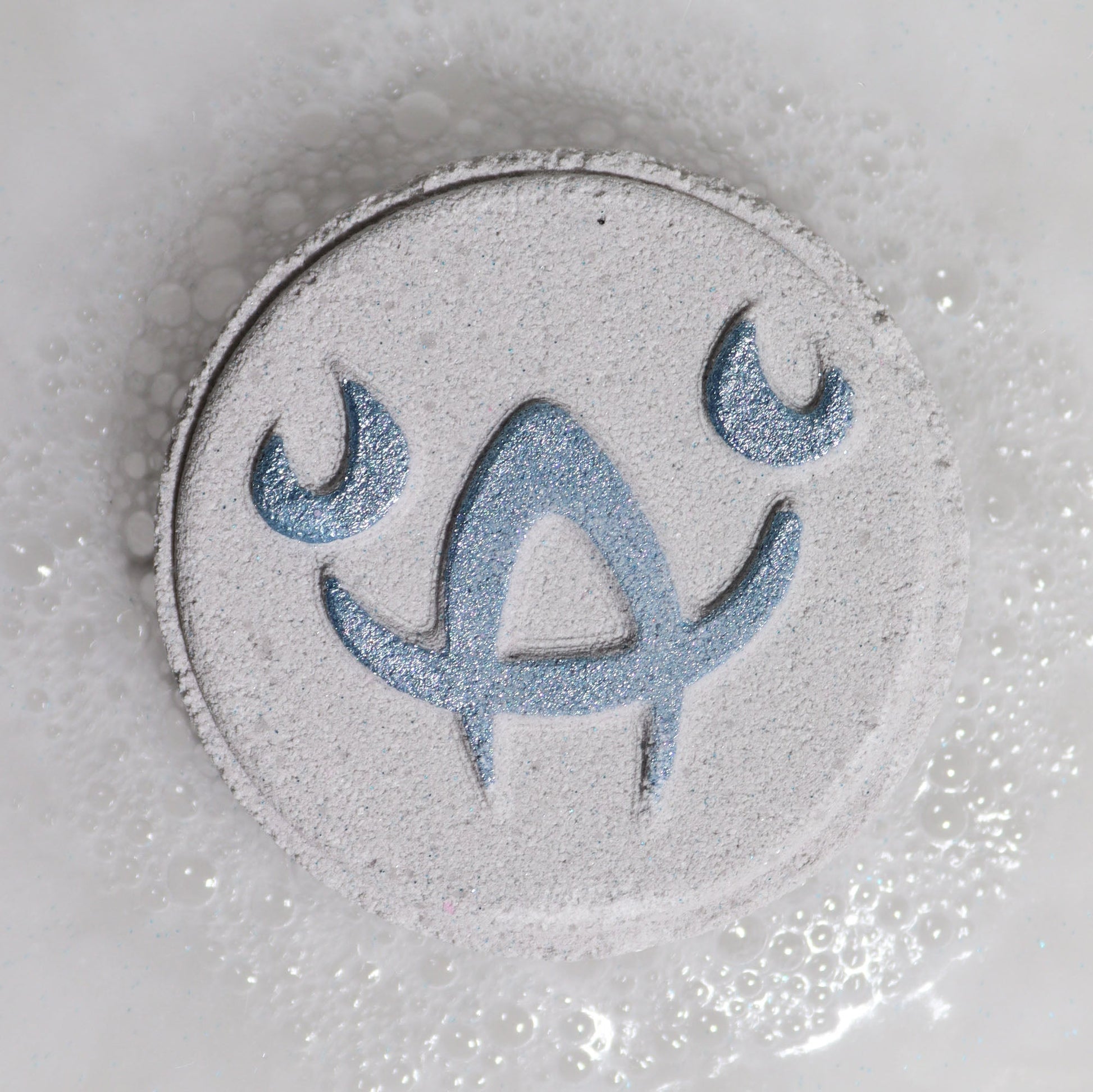 Cancer Bath Bomb Fizzers - Moonstone Eclipse - 2 Pack, close-up of a pale grey round fizzer embossed with the Cancer symbol by Quintessential Holistic Health Ltd